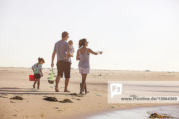 Familie in voller Länge am Strand bei klarem Himmel