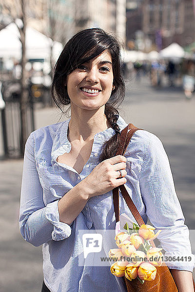 Porträt einer Frau mit Geldbörse auf der Straße stehend