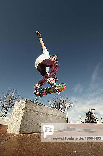 Niedrigwinkel-Ansicht eines Mannes  der im Skateboard-Park über die Stützmauer springt