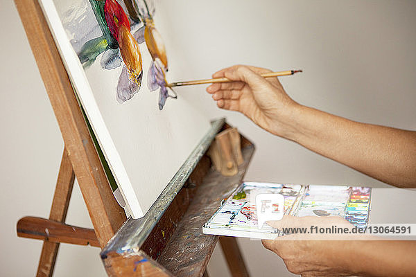 Beschnittenes Bild einer Künstlerin beim Malen im Atelier
