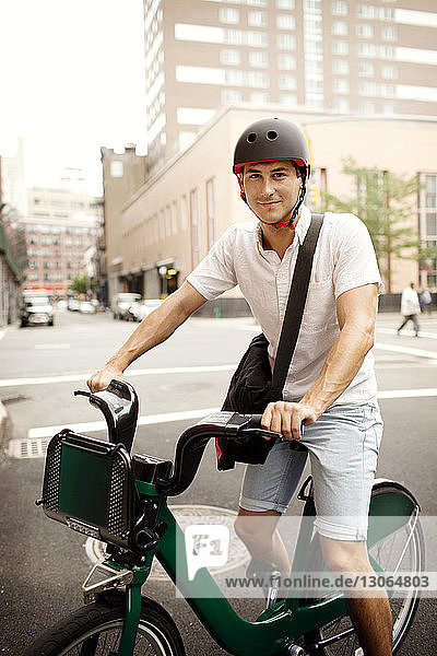 Portrait of man with bicycle on street