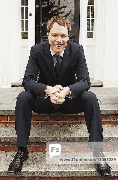 Portrait of man sitting on front stoop