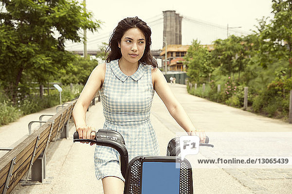 Radfahrende Frau auf Straße gegen Brooklyn Bridge in der Stadt