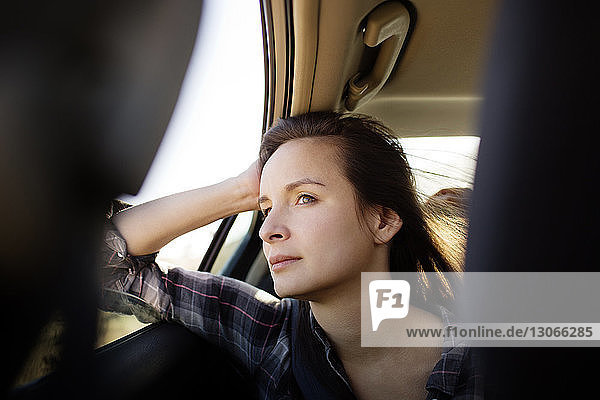Frau schaut weg  während sie im Auto sitzt