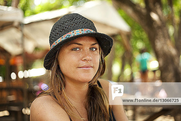 Porträt einer Frau mit Hut  die sich am Urlaubsort erfreut