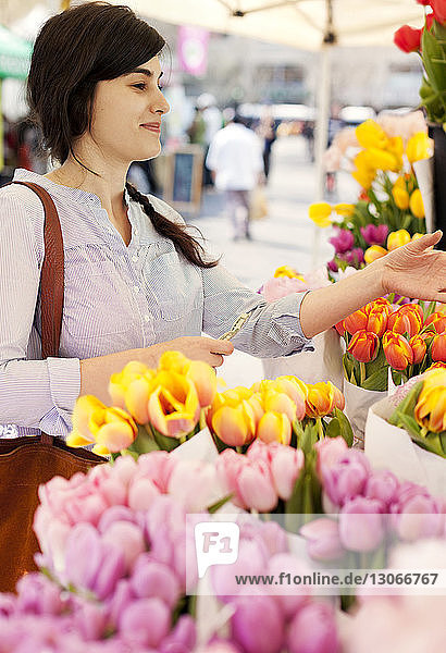 Frau kauft Blumen im Blumenladen-