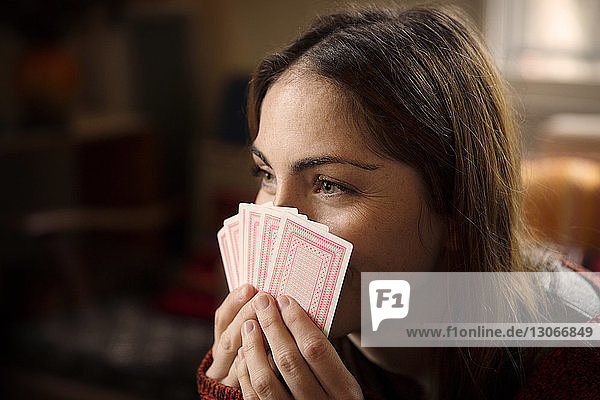Nahaufnahme einer Frau  die beim Spielen zu Hause Karten hält