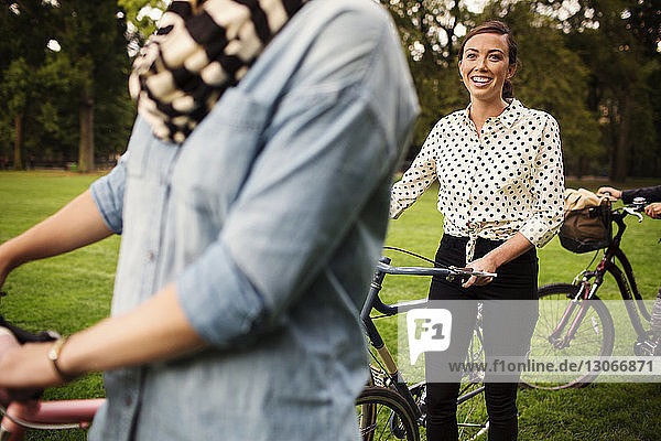 Freunde mit Fahrrädern zu Fuß auf dem Feld im Central Park