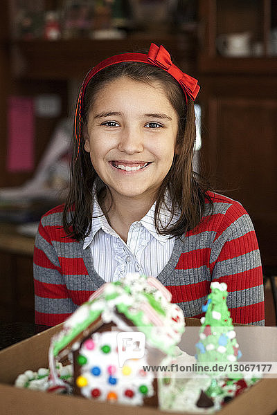 Portrait of smiling girl with gingerbread house