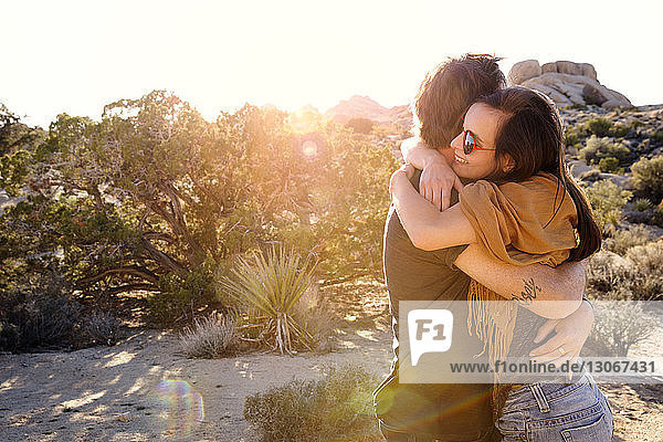 Glückliches Paar umarmt sich an einem sonnigen Tag vor klarem Himmel