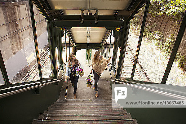 Hochwinkelansicht von Frauen beim Treppensteigen am Bahnhof