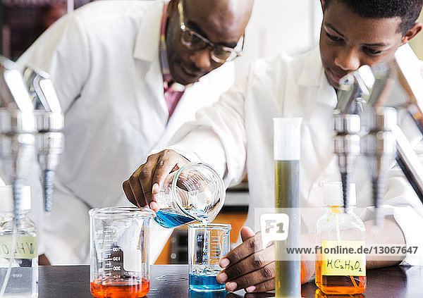 Lehrer betrachtet Schüler beim wissenschaftlichen Experiment an der High School