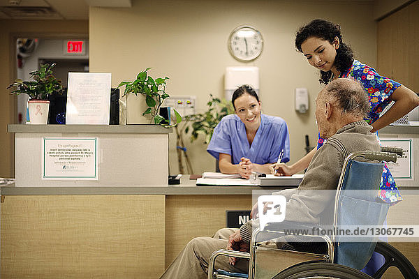 Ärztinnen im Gespräch mit älteren Patienten im Krankenhaus
