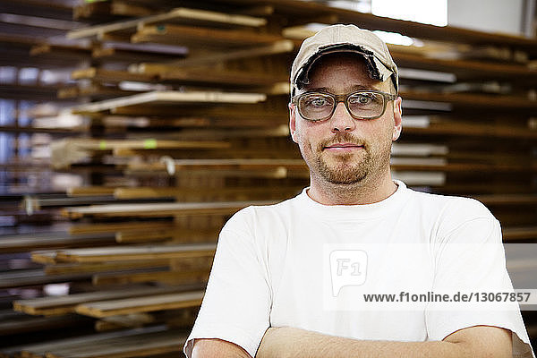 Portrait of confident carpenter standing in workshop