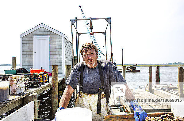 Porträt eines gegen den Himmel stehenden Mannes in der Fischereiindustrie