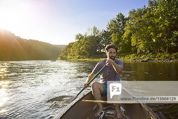 Mann rudert im Kanu sitzend