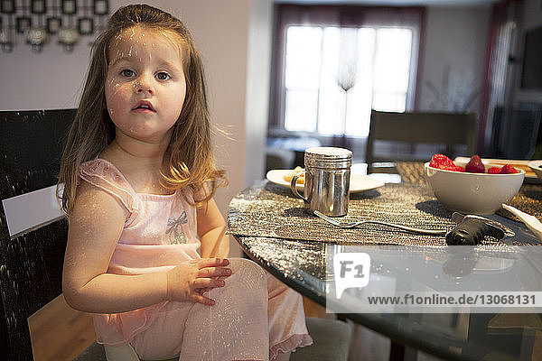 Porträt eines Mädchens  das zu Hause am Esstisch sitzt