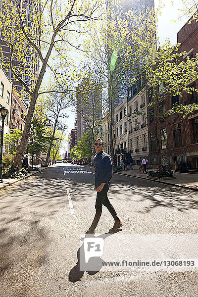 Mann mit Sonnenbrille geht auf der Straße