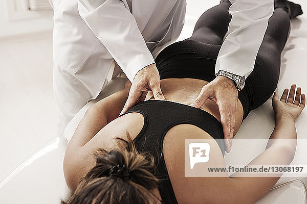 Osteopath examining woman at clinic