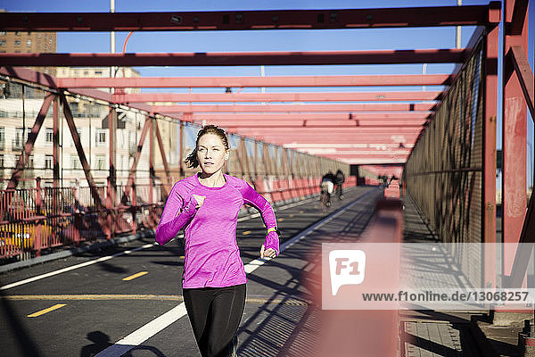 Frau läuft auf der Williamsburg Bridge Fußgängerweg