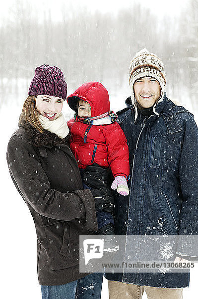 Porträt einer Familie auf schneebedecktem Feld stehend