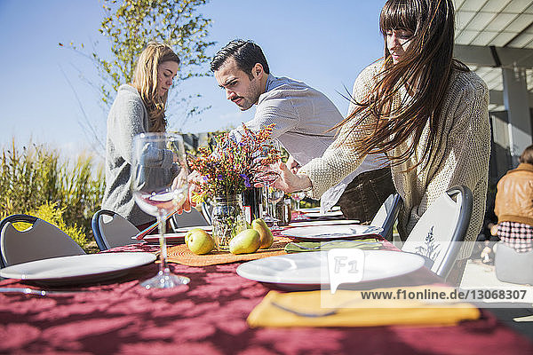 Friends arranging outdoor table during garden party