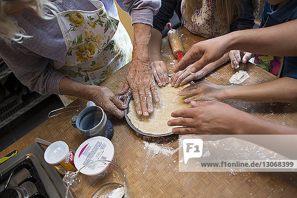 High angle view of family making dough in kitchen