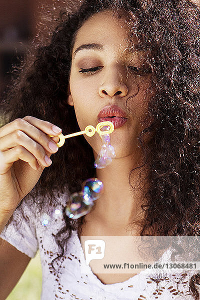 Low angle view of woman blowing bubbles