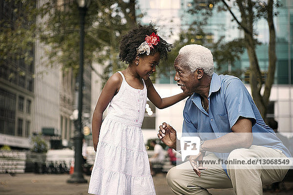 Enkelin spricht mit Großvater  während sie in der Stadt sitzt