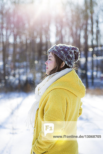 Seitenansicht einer Frau  die auf einem schneebedeckten Feld steht