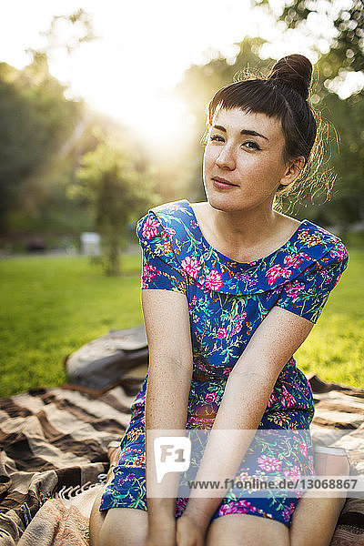 Porträt einer auf einem Grasfeld sitzenden Frau