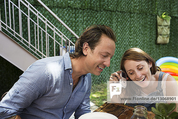 Couple listening music from mobile phone at backyard