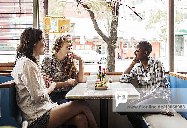 Freunde unterhalten sich  während sie im Restaurant sitzen