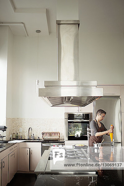 Frau hält Gefrierbeutel  während sie in der Küche steht