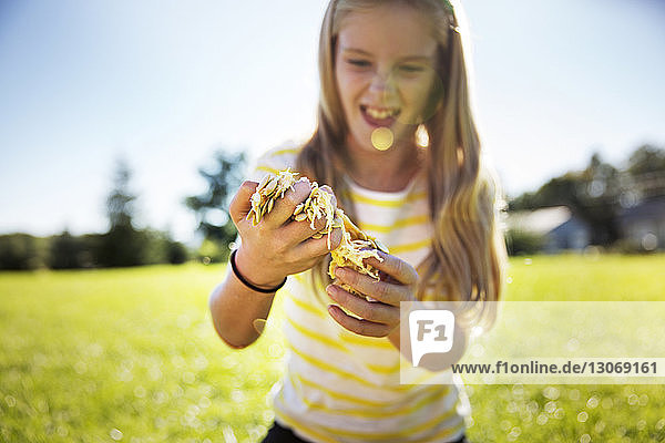Glückliches Mädchen hält im Sommer Kürbisfruchtfleisch auf dem Feld