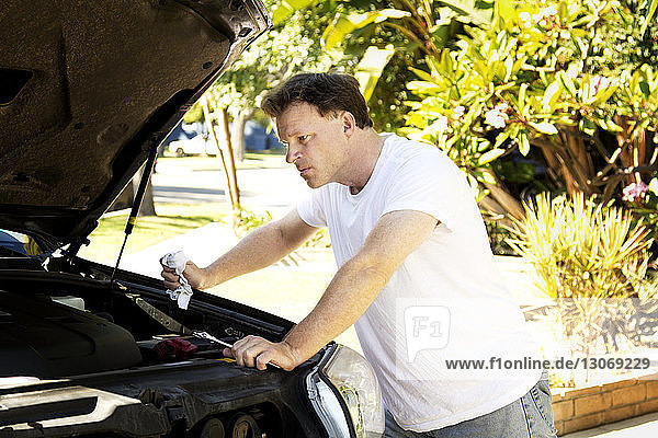 Mann repariert Auto im Hinterhof