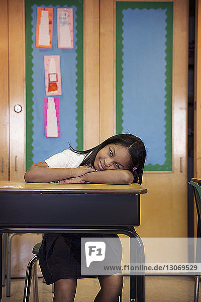 Portrait of girl sitting at desk in classroom