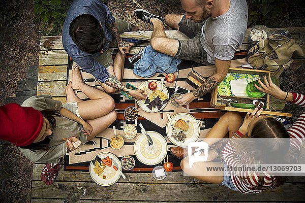 High angle view of friends having food while sitting on porch