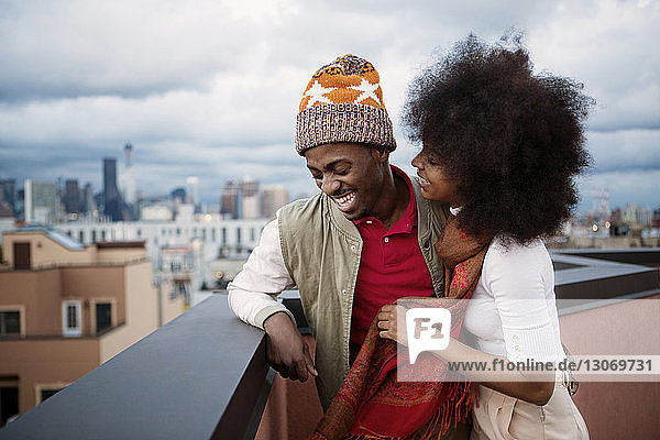 Fröhliches Paar steht auf Gebäudeterrasse