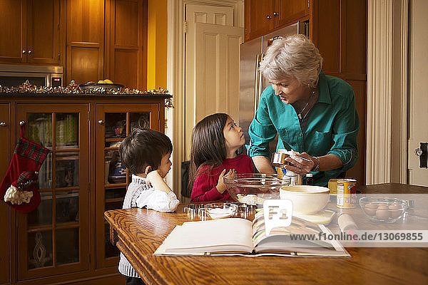 Grandmother with kids preparing cookies at home