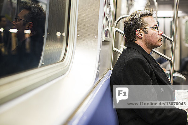 Mann schaut weg  während er in der U-Bahn fährt