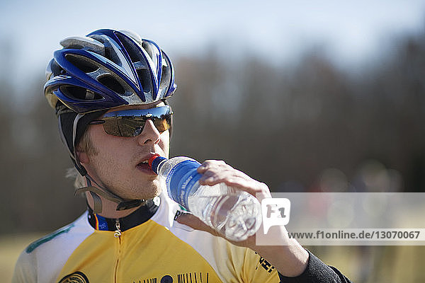 Cyclist drinking water while standing