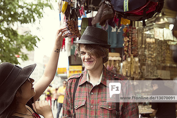 Glückliches Paar kauft Hut im Geschäft in der Stadt