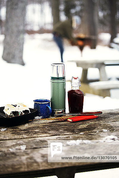 Gegenstände auf Holztisch im verschneiten Wald