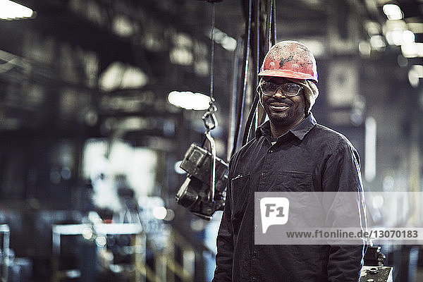 Portrait of smiling worker standing in factory