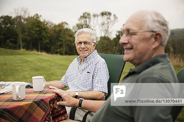 Ältere Männer sitzen am Tisch auf dem Rasen