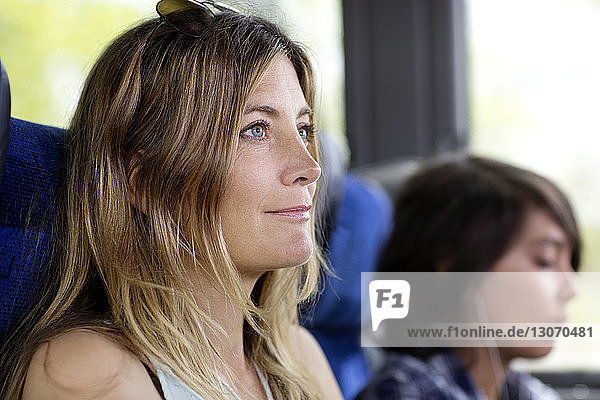 Frau schaut weg  während sie mit ihrem Sohn im Bus sitzt