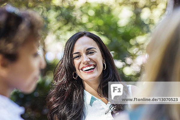 Woman laughing while standing by friends