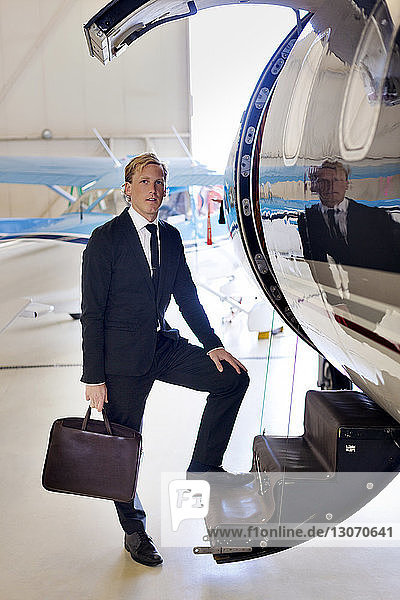 Porträt eines auf einer Flugzeugtreppe stehenden Geschäftsmannes