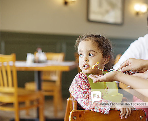 Mädchen schaut weg  während die Eltern im Restaurant essen